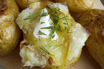 Spicy baked potatoes on wooden Board, closeup