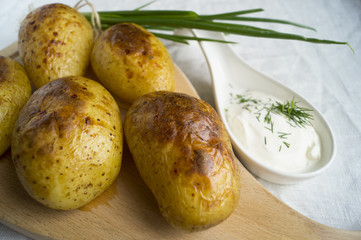 baked potatoes on a wooden Board with cream