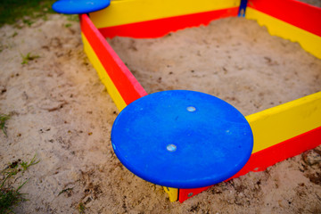 A nice sandbox playground filled . Surrounded by green grass,
