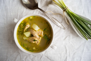Fresh fish soup with sour cream and onions, on a linen tablecloth.