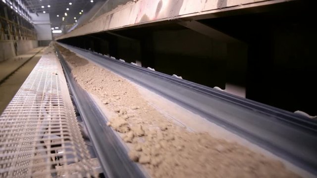 Soil, clay moving on conveyor belt. Soil, gravel, separation and refinement process. Clay mining. HD