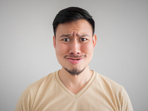 Headshot of funny guilty Asian man.