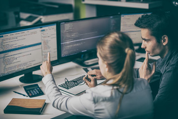 Man and woman working on computer in office