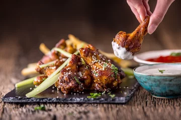 Fototapeten Chicken wings. Fried chicken wings in white bowl garlic dressing ketchup and potato fries. © weyo