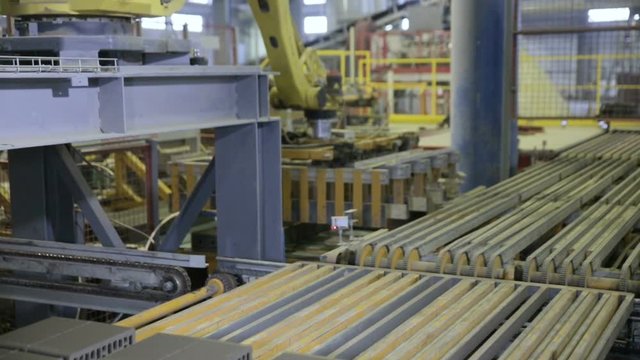 Robotic loaders work at a industrial factory. Indoors. HD.