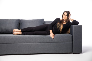 Beautiful woman lying on a white sofa, isolated on white