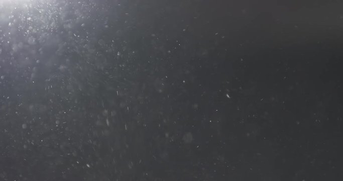 Slow motion of dust particles flow with light leak from above, 4k 60ps prores footage