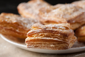 Detailed macro shot of delicious puff pastries in a white plate - obrazy, fototapety, plakaty