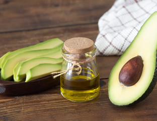 avocado and avocado oil on wooden background..