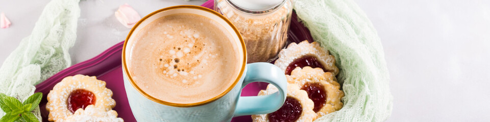 Mug of coffee cookies and pink ranunculus flowers. Festive holiday breakfast. Mother valentine day banner