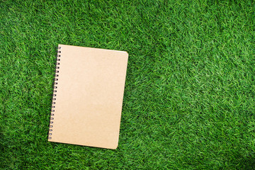 Education concept, Mobile phone with equipment and supplies for work on grass background.