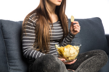 Pretty girl laughing, watching tv, sitting on sofa