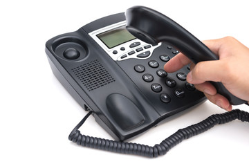 man dialing a black telephone on white background