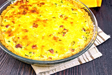 Quiche with pumpkin and bacon in pan on board