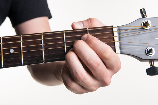 The guitarist's hand clamps the chord A on the guitar, on a white background. Horizontal frame