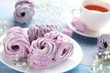 Sweet zephyr with cup of tea on blue wooden table