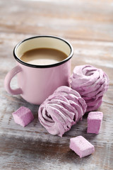 Sweet zephyr with cup of coffee on brown wooden table