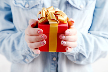 Female hands holding gift box with ribbon