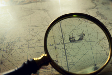 A book of old maps and a magnifier, retro styled 