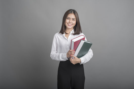 Beautiful teacher Woman holding book on grey background
