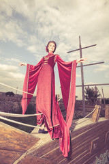 Fototapeta premium Beautiful woman in vintage clothes on a boat. Retro style. Elegance and glamour