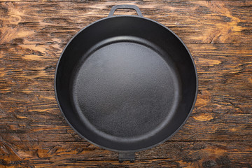 a cast-iron frying pan on a wooden background