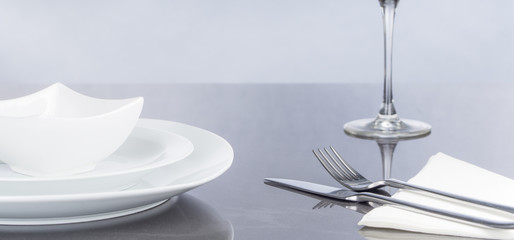 Messer und Gabel, Teller und Glas auf spiegelndem Tisch, Panorama, Hintergrund