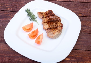 grilled pork chop with vegetable on plate on wooden board