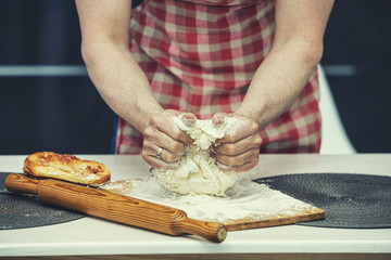 Hands closeup of a chef who makes the dough in the kitchen