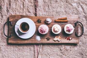 Cupcake and coffee on old dark rustic wooden table
