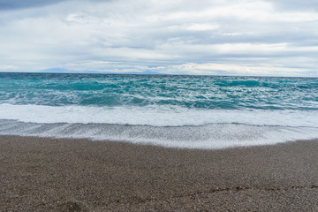 Fototapeta na wymiar Soft and gentle waves foam in blue ocean italy coast, summer evening as background