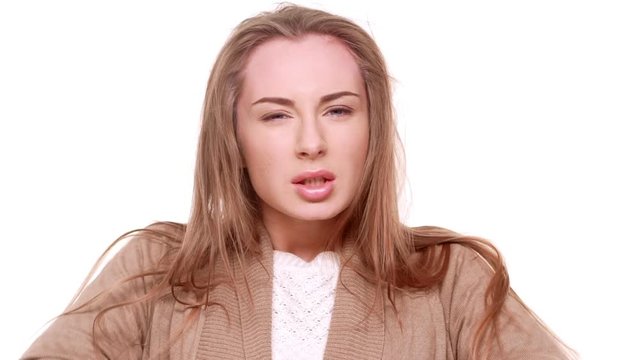 Furious Caucasian female standing trying to calm down standing on white background in slowmotion
