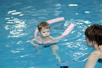 Fototapeta na wymiar Mother and her son in swimming pool
