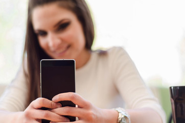 Young smiling girl making selfie on the background of the high key
