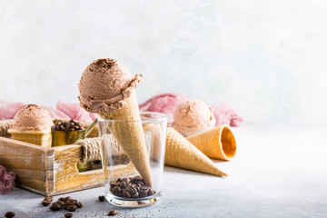 Waffle cone with coffee ice cream in glass and ingredients in wooden tray. Healthy summer food concept with copy space.