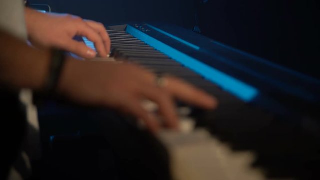 A man is playing a synthesizer. Close-up of hands