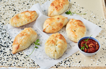 Fresh baked pasties filled with meat, vegetables and adjika sauce. Cornish Pasty