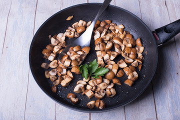 frisch gebratene Champignons mit Petersilie in der Pfanne