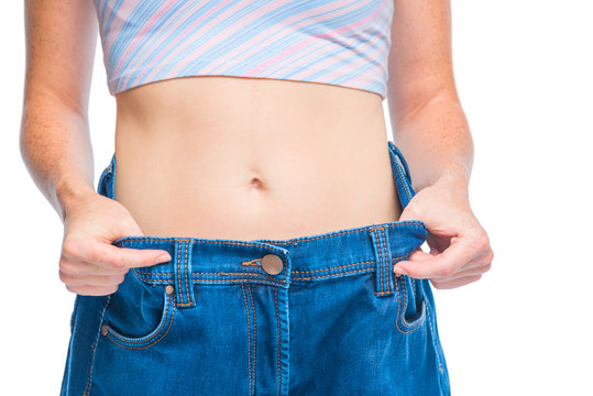 Belly slender girl close-up in big size jeans