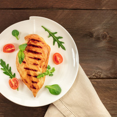 Grilled chicken fillet with cherry tomatoes and salad leaves