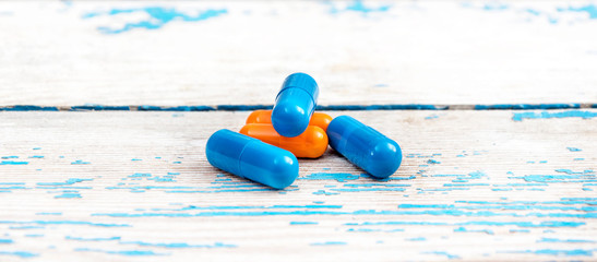 Medical capsules on the wooden table. Close up. Medical concept.