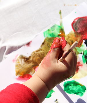 mano de ni&ntilde;o peque&ntilde;o manchada de pintura 