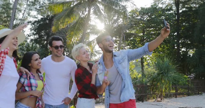 People Group Taking Selfie Photo On Cell Smart Phones Talking Happy Men And Women Over Tropical Palm Trees Slow Motion 60