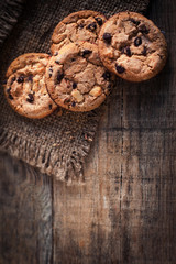 Chocolate cookies on dark  napkin on wooden table with copyspace. Closeup of a group of assorted cookies..