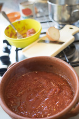 preparing tomato sauce in earthenware saucepan
