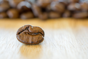 Coffee bean on wooden table closeup.