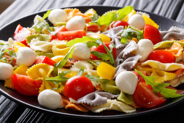 Farfalle pasta with tomatoes, arugula and mozzarella close-up. horizontal