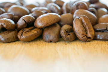Coffee beans on wooden table closeup.