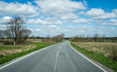 blauer Himmel mit wolken auf einer Nebenstrasse