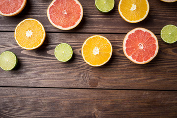 Fototapeta na wymiar Colorful citrus halves on wooden table. Food background